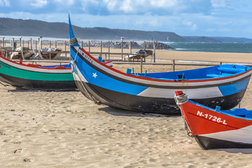 Naklejka na ściany i meble Detailed view of colored and traditional fishing boats on the Nazare beach