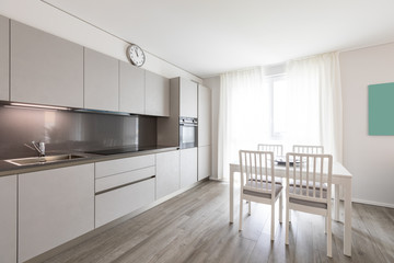 Modern gray kitchen with white chair and table