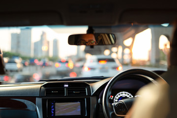 Woman looking bored in her car while stuck in traffic jam.