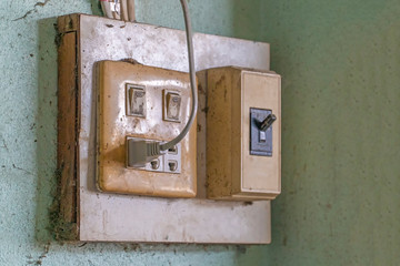 The old electrical plug next to the cream wall.