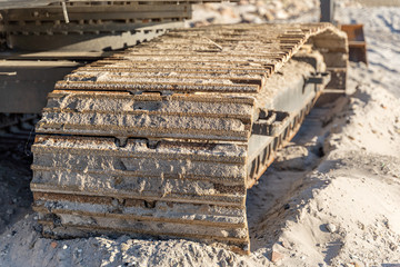 close up details of excavator tracks on construction site