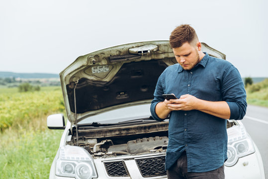 Man Stand In Front Of Broken Car