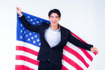 A business man has a large smile and hold the American flag behind his back