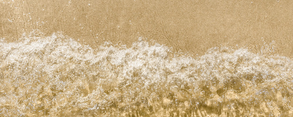 Wave and sandy seashore - panoramic background, top view, beach vacation, copy space