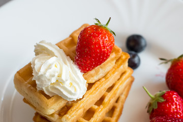  Belgian waffles with Strawberry and Blueberries on white blate close up