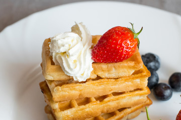  Belgian waffles with Strawberry and Blueberries on white blate close up