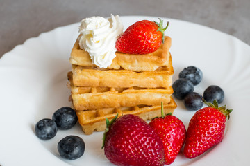  Belgian waffles with Strawberry and Blueberries on white blate close up