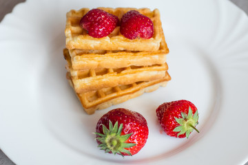 Close up of  belgian waffles with strawberries on the table 