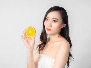 Obraz na płótnie Canvas portrait asian beautiful woman.Closeup beauty skin face young girl.isolated white background. female holding orange