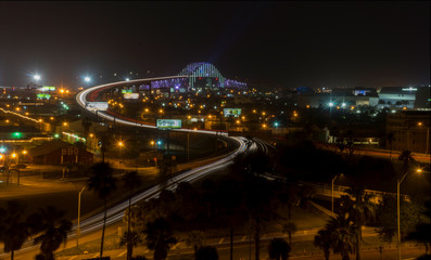 Fototapeta na wymiar Streaked lights Of Cars at Night Crossing Bridge