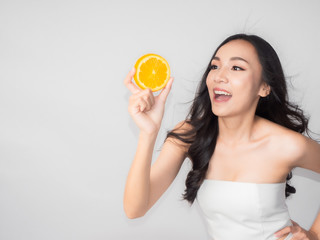 portrait asian beautiful woman.Closeup beauty skin face young girl.isolated white background. female holding orange