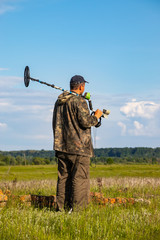 Treasure hunter in the field with a metal detector