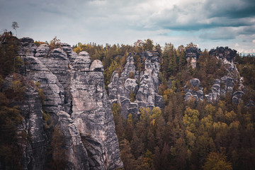 Fototapeta na wymiar View of Sandstone Rocks in Saxon Switzerland National Park, Germany. Mountains, green trees. Spring or summer season. Nature theme.