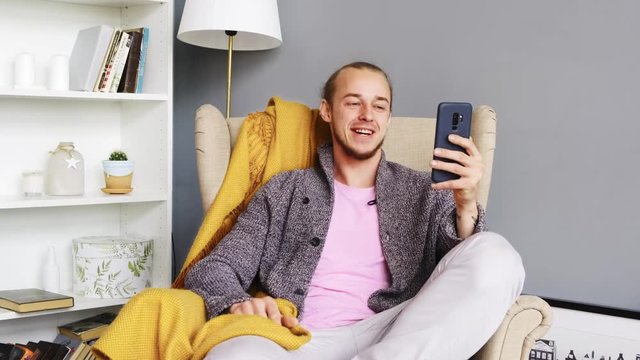 Young man talking and having video call, looks at the phone. Face time. Live. Front-camera. Web cam. Mobile phone