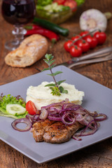 Gegrilltes Schweinesteak mit Zwiebeln
