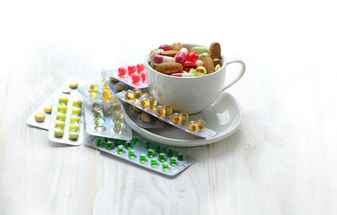 Different colorful medications pill close up. Many different drug and pill in Cup on white...