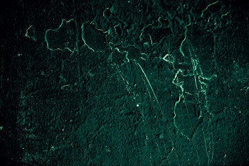 Vintage green background. Rough painted wall of emerald color. Imperfect plane of virid colored. Uneven old decorative toned backdrop of green tint. Texture of emerald hue. Ornamental stony surface.