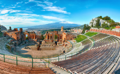 Fototapeta na wymiar Ruins of ancient Greek theater in Taormina and Etna volcano in the background.