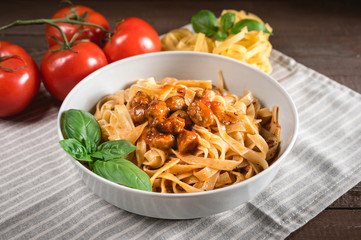 Italian spaghetti and meatballs topped with fresh basil