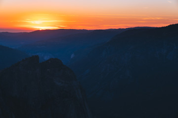 A very warm sunset in the countryside, with the sun hiding behind mountains