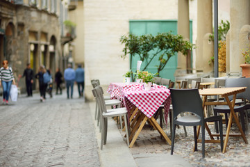 Fototapeta na wymiar Beautifully decorated small outdoor restaurant tables in the city of Bergamo, Italy