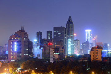Fototapeta premium Nanjing Daxinggong CBD with the New Century Plaza Tower at the center at night in downtown Nanjing, Jiangsu Province, China.