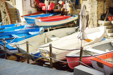 Fototapeta na wymiar Colourful boats in tiny marina of Riomaggiore, the largest of the five centuries-old villages of Cinque Terre, Italian Riviera, Liguria, Italy.