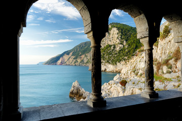 Columns of famous gothic Church of St. Peter with beautiful shoreline scenery in Porto Venere village, Liguria, Italy