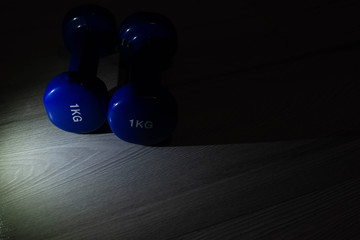 Blue dumbbells on the floor of 1 kilogram