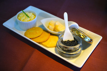 Expensive gourmet black sturgeon caviar fish roe with blinis and a mother-of-pearl spoon