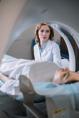 selective focus of radiologist standing near patient during tomography diagnostics