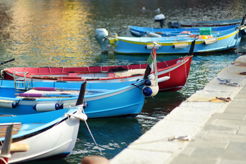 Fototapeta na wymiar Colourful fishing boats in small marina of Vernazza, one of the five centuries-old villages of Cinque Terre, located on rugged northwest coast of Italian Riviera.
