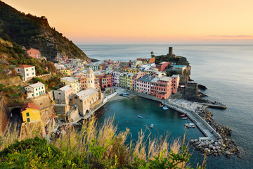 Fototapeta premium Kolorowe domy i mała marina Vernazza, jedna z pięciu wiekowych wiosek Cinque Terre, położona na skalistym północno-zachodnim wybrzeżu Riwiery Włoskiej.