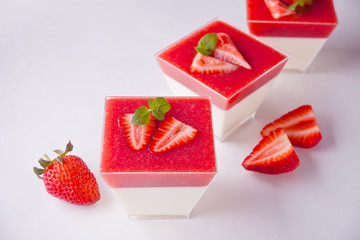 Dessert panna cotta with fresh strawberries on white background, selective focus