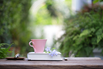 Pink coffee cup with small flowers and notebook 
