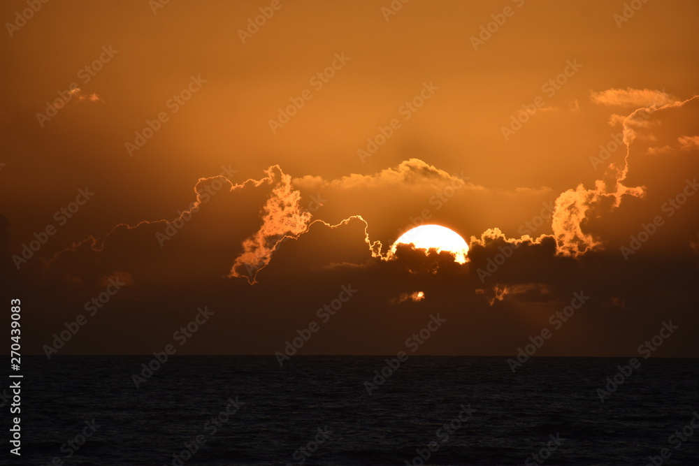 Wall mural dramatic sunsets and sunrises over the coastal beaches and ocean of tropical florida