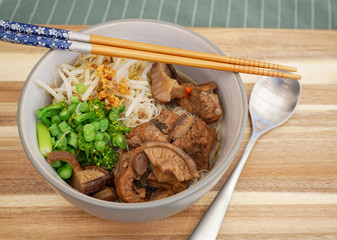 Top view of Slow cooked pork spare noodles with shiitake Mushroom and mixed vegetables or Braised pork noodle soup, Thai, Chinese and Taiwanese cuisine