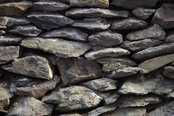 Old grey granite wall built of ancient stonework, abstract background with place for text.