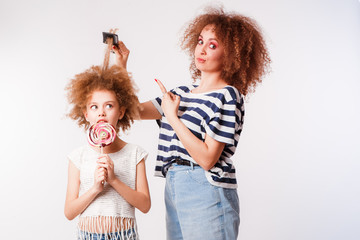 Mom combs her daughter's naughty, curly hair.