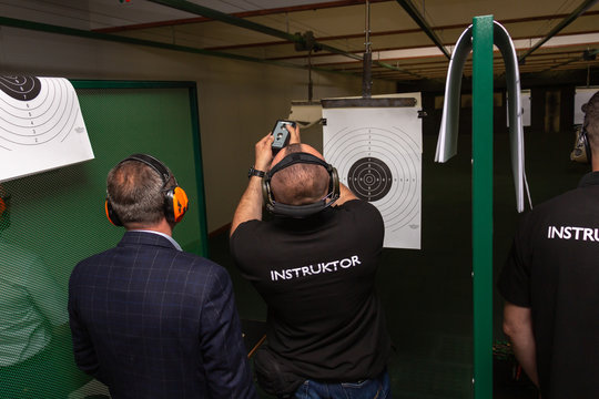Shooting in the dash of short-barreled weapons. The instructor in special ballistic headphones attaches the target before firing