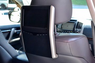 Entertainment system for rear passengers in a car with two monitors mounted on the backs of the...