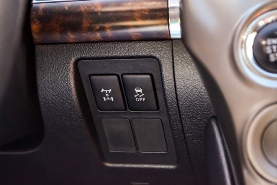 The button for the stability control system and locking the center differential on black panel of car near the steering wheel to overcome off-road, impassable roads and drive safely in snow or rain