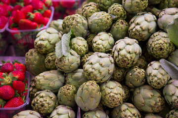 Obraz premium Green artichokes showing on a shelf of the central market