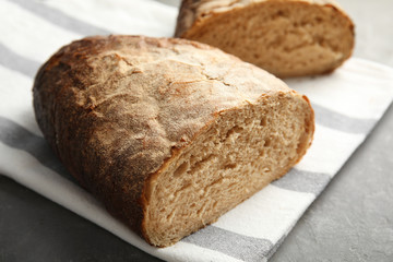 Cut loaf of bread on grey table, closeup