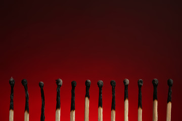 Line of burnt matches on color background. Space for text