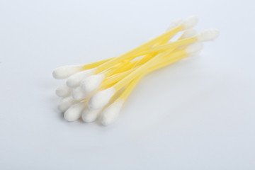 Yellow plastic cotton swabs on white background