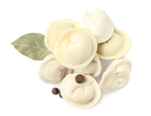 Pile of raw dumplings with bay leaf and pepper on white background, top view