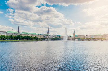 Fototapeta premium Hamburg cityscape on sunny day against blue sky with Alster lake and fountain in foreground