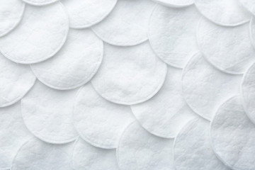 Many cotton pads as background, top view