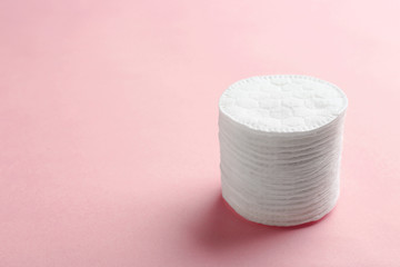 Stack of cotton pads on color background. Space for text